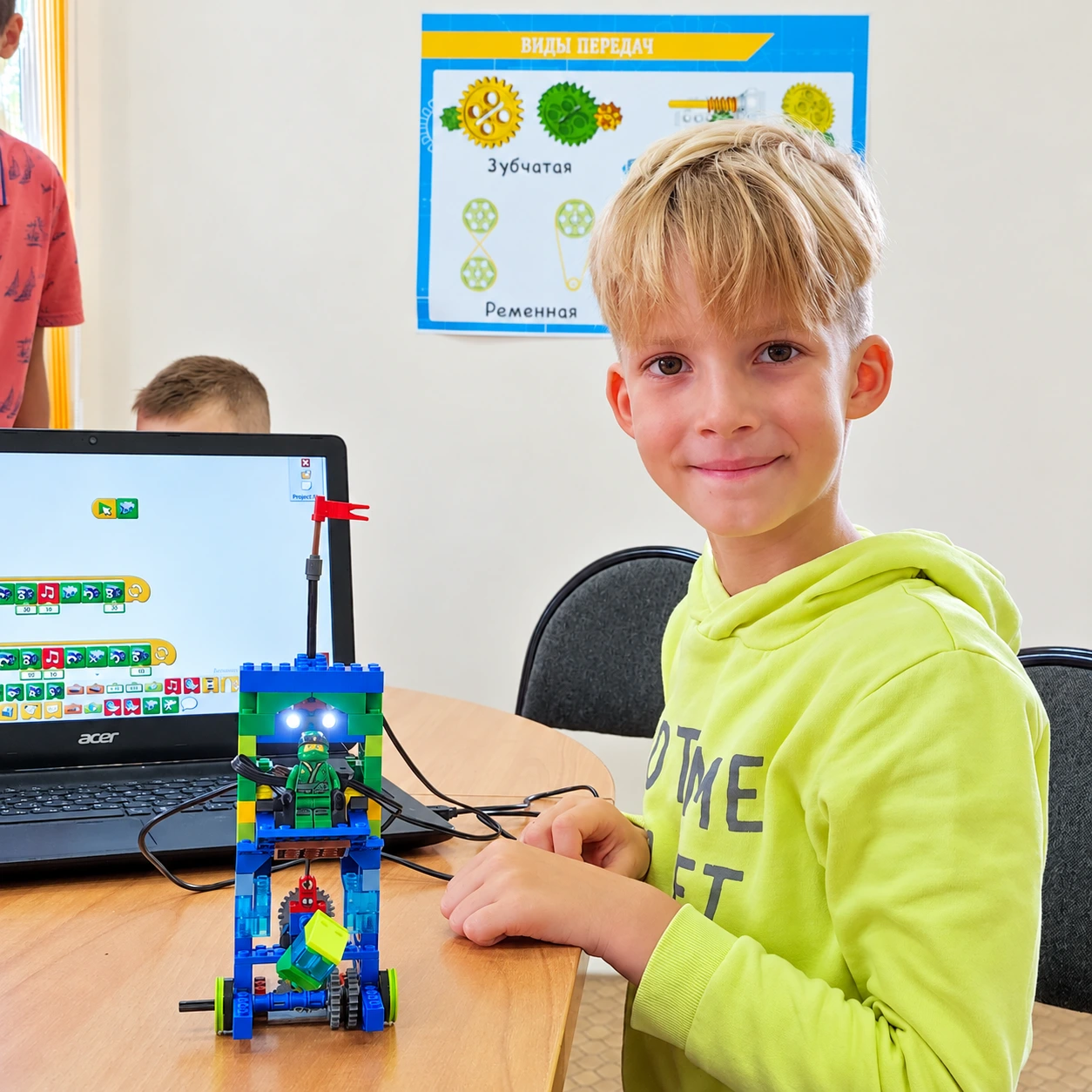 Ученик курса «Ниндзяго 2» в салатовой толстовке с высокой LEGO-моделью и фигуркой ниндзя