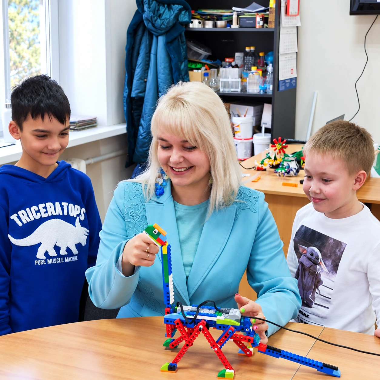 Преподаватель и ученики с подвижной моделью динозавра LEGO