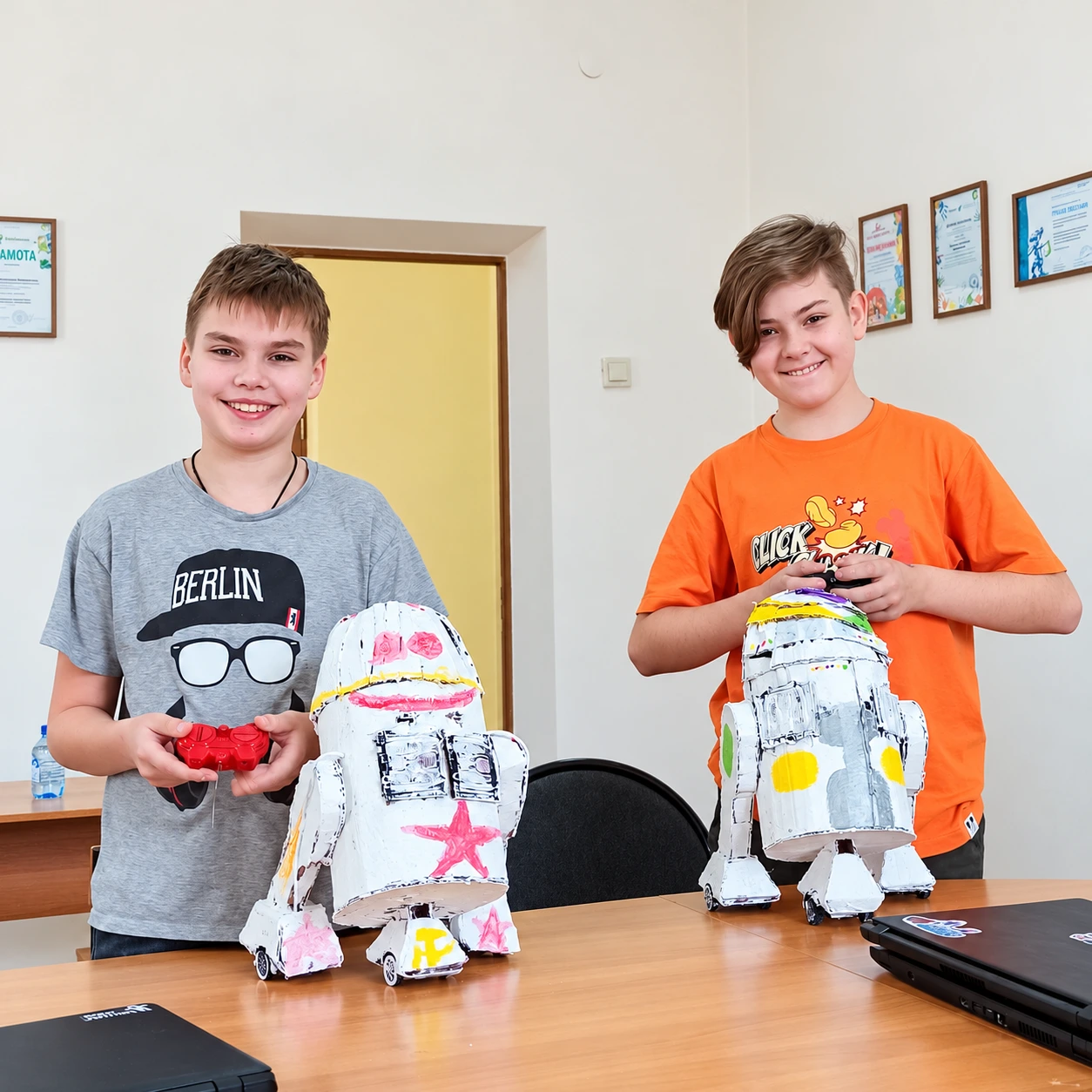 Два ученика с созданными ими картонными роботами