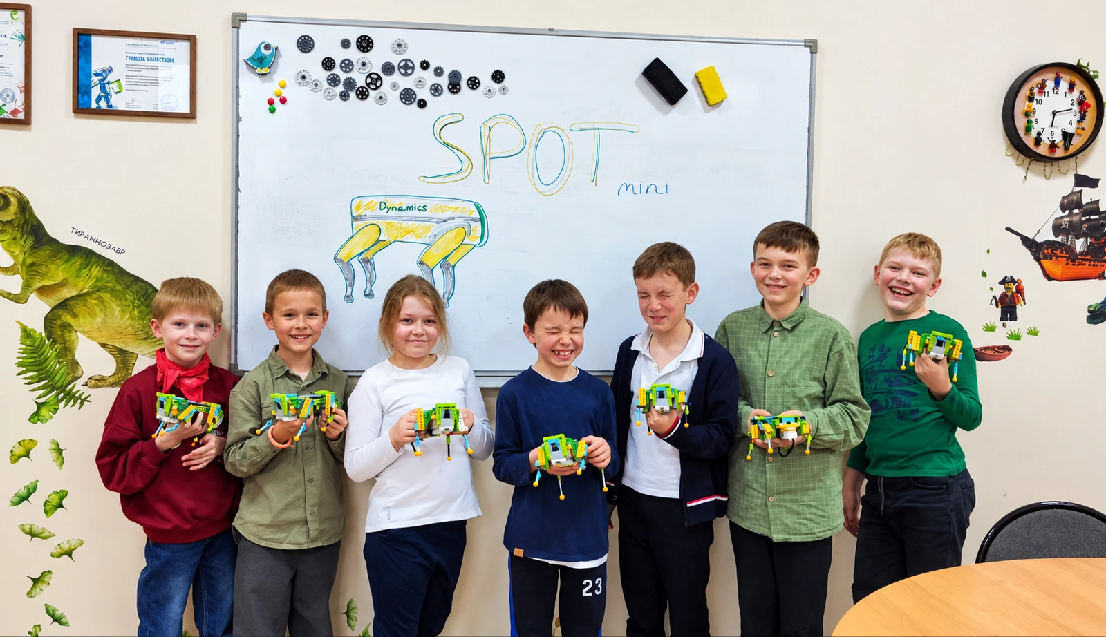 Ученики LEGO-физики с шагающими моделями у доски SPOT mini