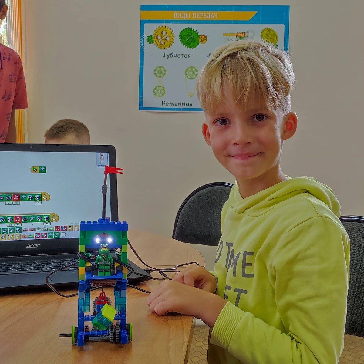 Ученик курса «Ниндзяго 2» в салатовой толстовке с высокой LEGO-моделью и фигуркой ниндзя