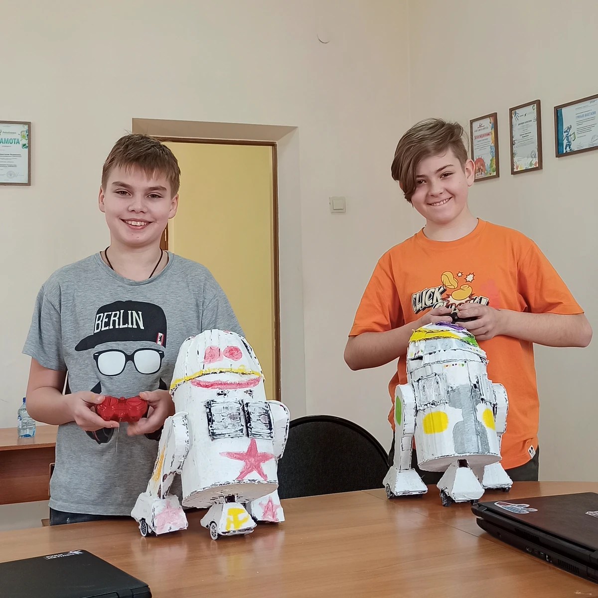 Два ученика с созданными ими картонными роботами