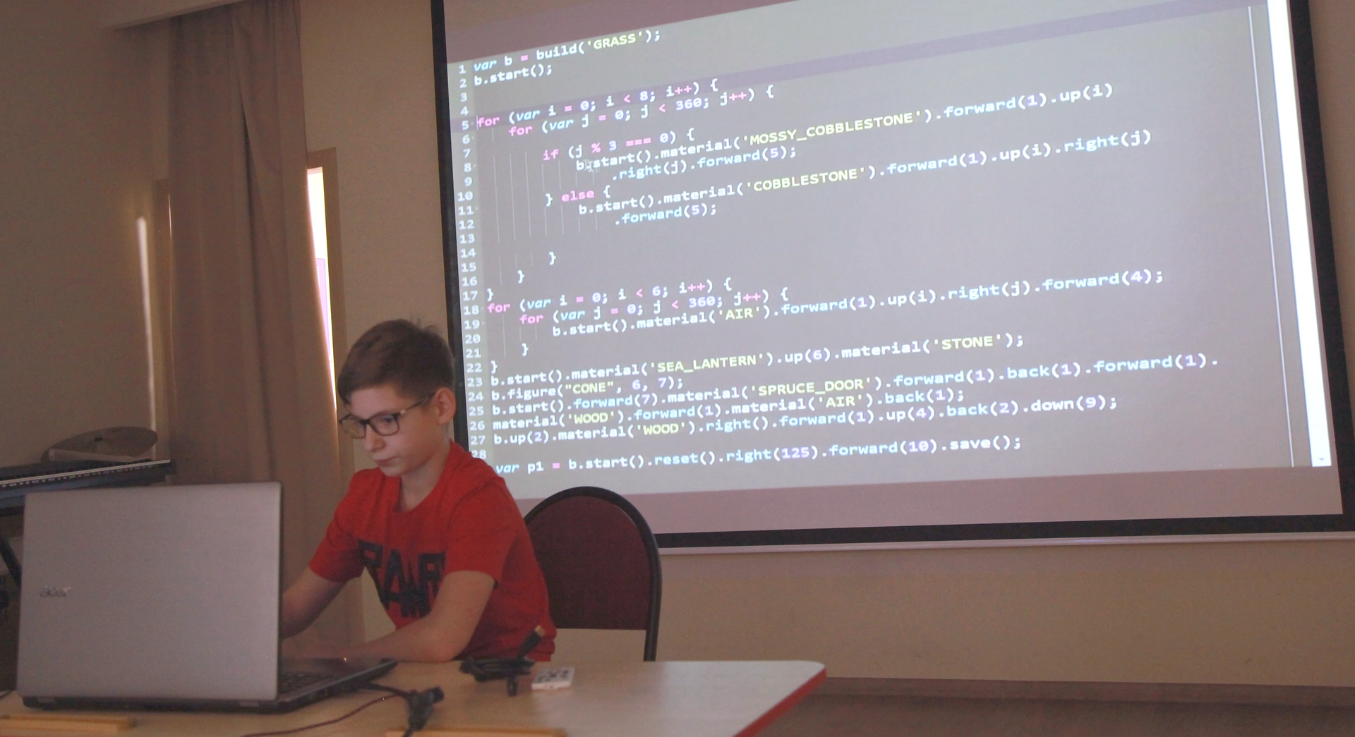 Ученик за ноутбуком на фоне проекции кода JavaScript